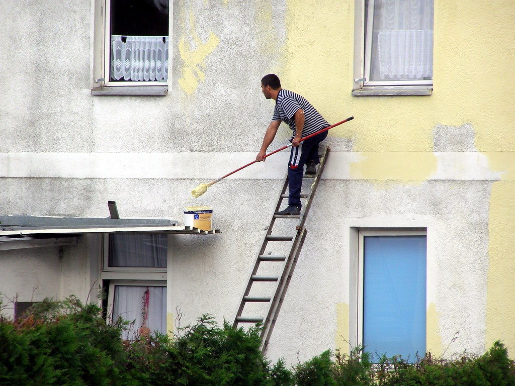 外壁を塗装する職人(サンプル写真)